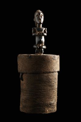 une image représentant une petite figurine posée sur une boîte en bois