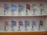 de nombreuses petites figurines représentant des personnes tenant des drapeaux, exposées dans une vitrine