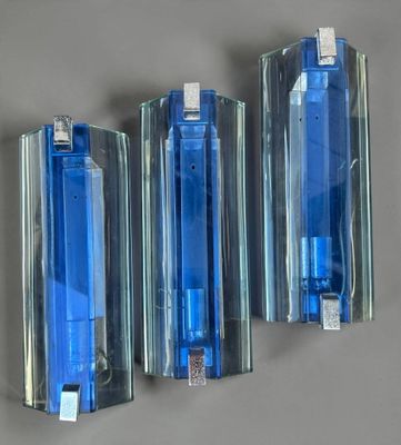 three blue lighters sitting on a wall next to each other