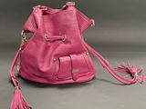 a close up of a pink purse with a tassel on it
