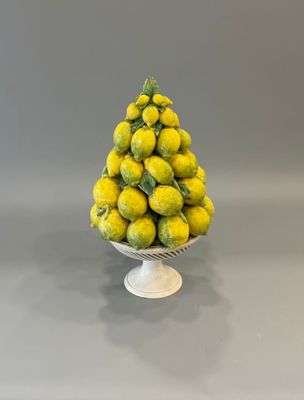 un petit bol blanc rempli de citrons posé sur une table