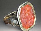 an image of a ring with a carved coral stone in it