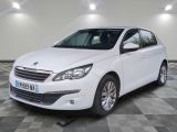 la voiture blanche est garée sur un sol en damier dans le garage