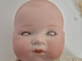 a close up of a doll with a white dress on