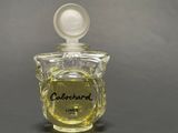 a bottle of cologne sitting on a table with a lid