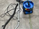 un aspirateur bleu et un seau bleu posés par terre