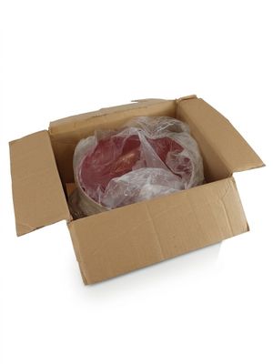 une boîte en carton contenant de la viande, posée sur une surface blanche