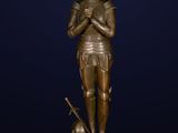 a bronze statue of a woman holding a sword and a shield