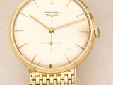 a close up of a gold wrist watch on a white surface