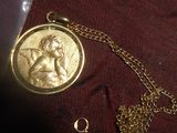 une pièce d'or représentant un ange, suspendue à une chaîne