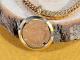 an image of a necklace with a coin on it on a yellow background