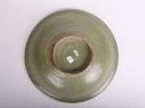 a green plate with a brown rim on a white table