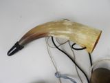a horn with a rope and a bottle of wine on the table
