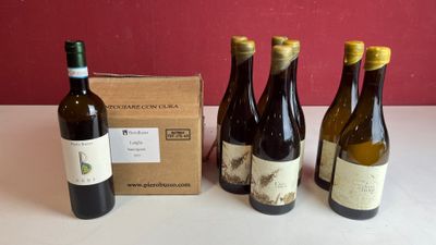quatre bouteilles de vin sont alignées sur une table, à côté d'une boîte