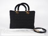 a black handbag with a gold chain strap and a white bag