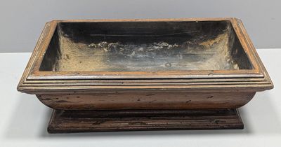 an old wooden box with a metal lid sitting on a table