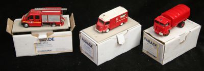 trois petits camions rouges posés sur une boîte