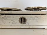 a white marble box with two silver plates on top of it