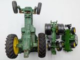 a green toy tractor and a green toy tractor on a white surface