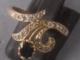 an image of a gold ring with black and white stones on it