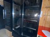 une douche en verre dans une petite pièce avec un plan de travail rouge