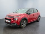 La Citroën rouge est garée dans une pièce au sol noir.