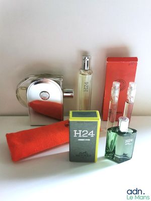 un flacon de parfum à côté d'un coffret de parfum et d'une serviette rouge