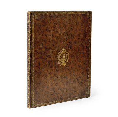 un livre en cuir marron orné d'un emblème doré