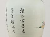 a white vase with asian writing on it sitting on a table