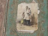 an old book with a picture of a woman sitting on top of it