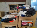 several boxes of clothing are stacked on top of each other in a room