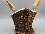 a close up of a piece of wood with two forks sticking out of it