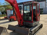 a red excavator that is sitting in the dirt