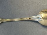 a silver spoon with a spoon handle on a table