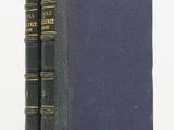 a blue book sitting on top of a white table next to a pair of books