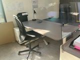 a desk with a chair and a computer on it