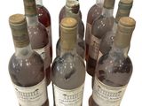several bottles of wine are lined up in a row on a white surface