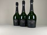 trois bouteilles de champagne posées sur une table blanche