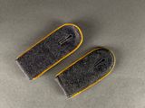 pair of grey and yellow felt ear plugs on a gray surface