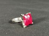 pink stone ring with silver setting on a black surface