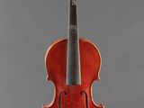 an old violin sitting on a stand against a gray background