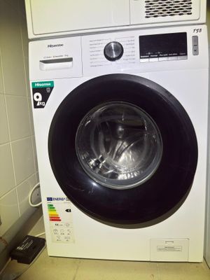 a washing machine that is sitting in the corner of the room