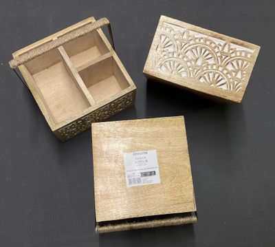 Trois petites boîtes en bois sont posées sur une table