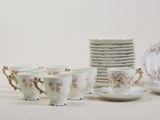 a lot of cups and saucers sitting on a table