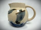 a white pitcher with a blue and white design on it