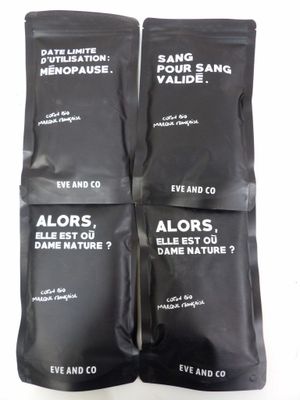 three bags of coffee sitting on top of each other on a table