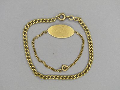 Gros plan sur un bracelet en chaîne en or portant une étiquette