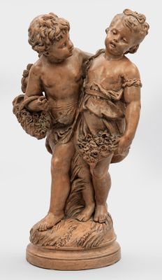 deux statues représentant un garçon et une fille tenant des paniers de fleurs