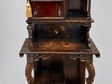 une vieille armoire en bois avec une porte en verre rouge et des étagères