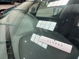 a sticker on the windshield of a car that is parked in a parking lot